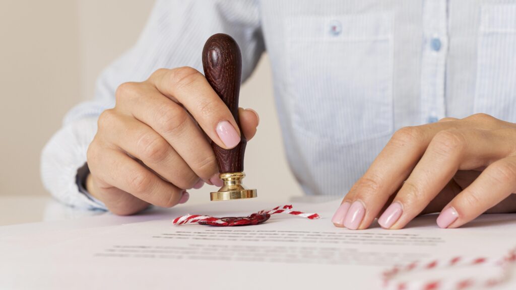 Close-up of a person applying a wax seal on official legal document for apostille or attestation services in the UAE, symbolizing document authentication and international legalization process